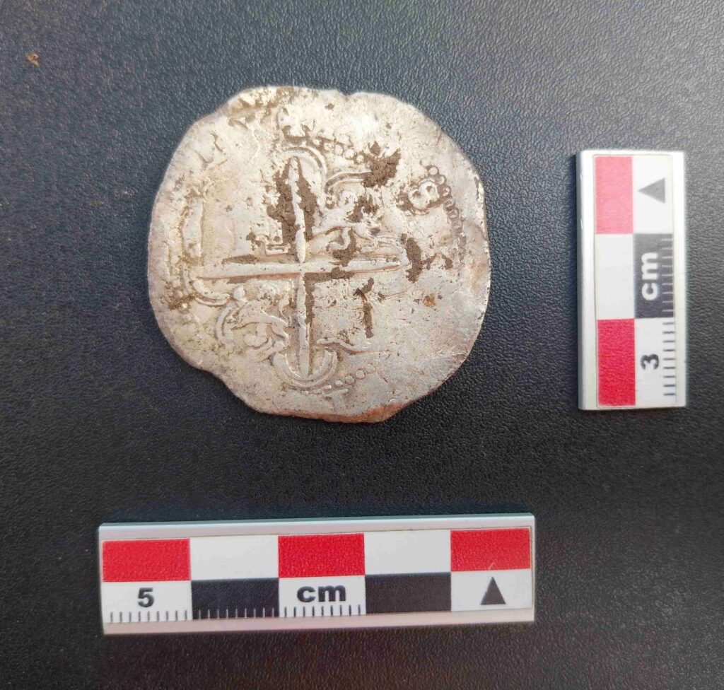 A 400-year-old silver coin unearthed near the Strait of Magellan has pinpointed the exact location of a doomed Spanish colony where most of 350 settlers perished within years.