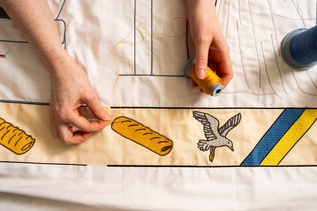 Greggs has unveiled a Bayeux Tapestry-inspired Ta-Pastry with 5.5 million stitches tracing the sausage roll's near-century history, on display at London's Design Museum.