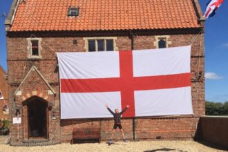 A lucky Brit has won a monster 24ft England flag wide enough to cover his entire house front - described as the length of three-and-a-half Peter Crouchs laid end to end.