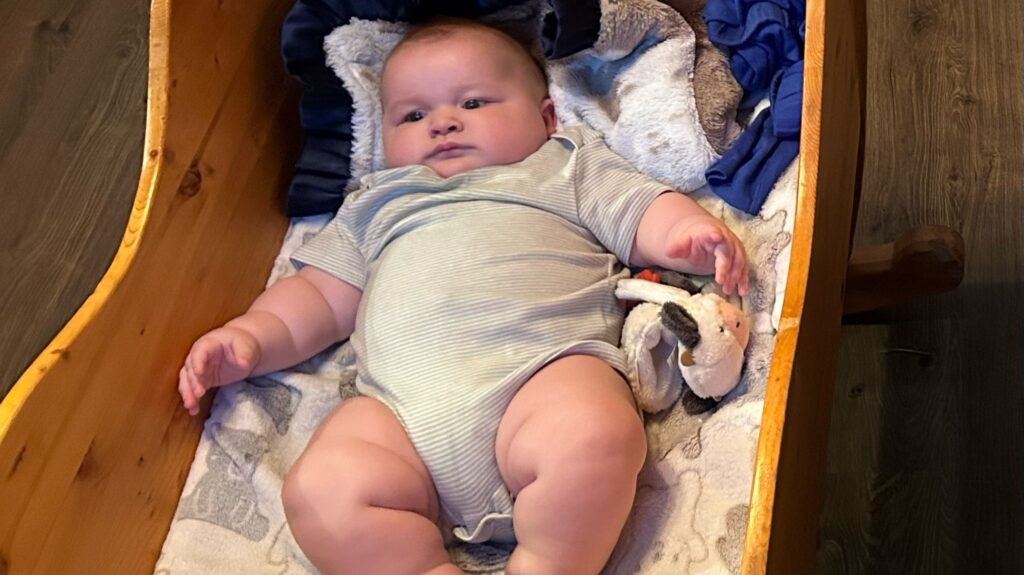 A mum says her eight-month-old baby is already wearing clothes for five-year-olds and has cost $5,000 in outgrown equipment - adding that she carries him "with hope and prayer".