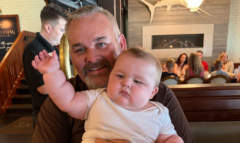 A mum says her eight-month-old baby is already wearing clothes for five-year-olds and has cost $5,000 in outgrown equipment - adding that she carries him "with hope and prayer".