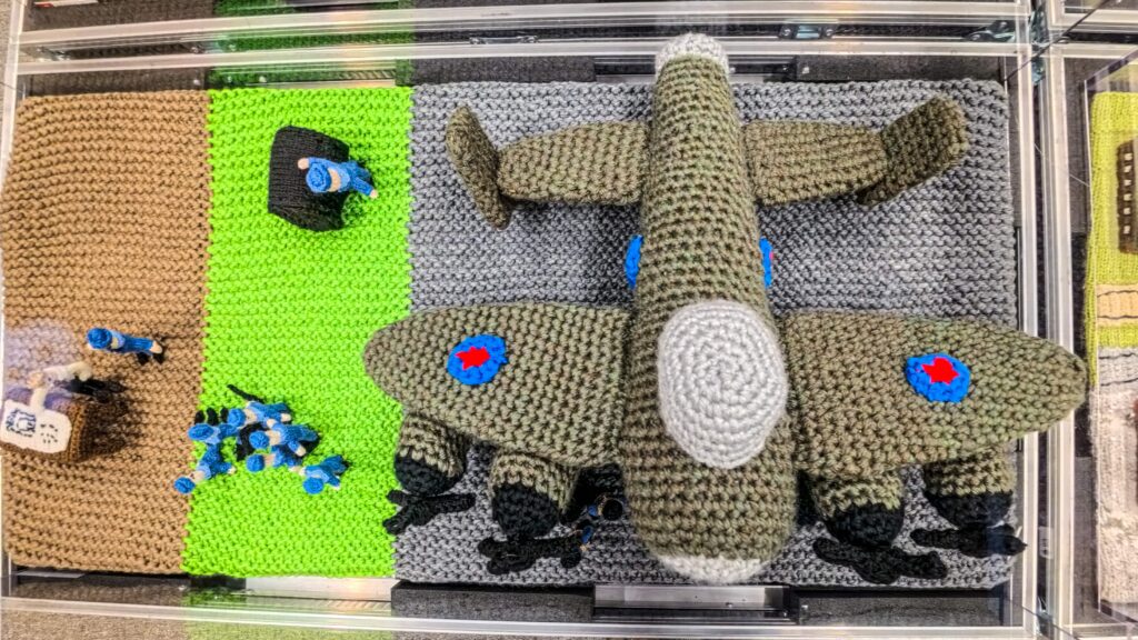 An extraordinary 80-metre exhibition depicting the D-Day landings, Spitfires and the Blitz has been created entirely from knitting and crochet by 200 volunteers.