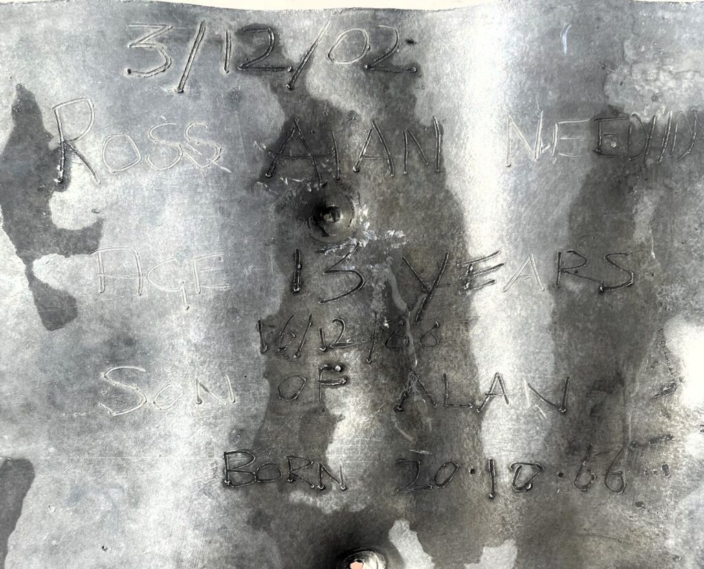 A roofer was left fighting back tears after uncovering a photo of his teenage son he had secretly hidden beneath a roof slate 24 years earlier - with his son working beside him.