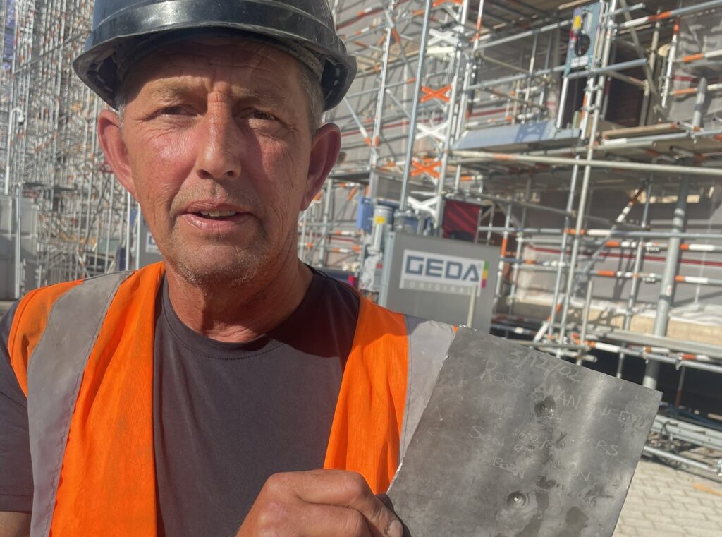 A roofer was left fighting back tears after uncovering a photo of his teenage son he had secretly hidden beneath a roof slate 24 years earlier - with his son working beside him.