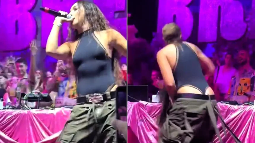 Reggaeton star Lola Indigo sent her wig flying with a dramatic head flick mid-performance in Ibiza - but the singer laughed it off and waved it at the cheering crowd like a pro.