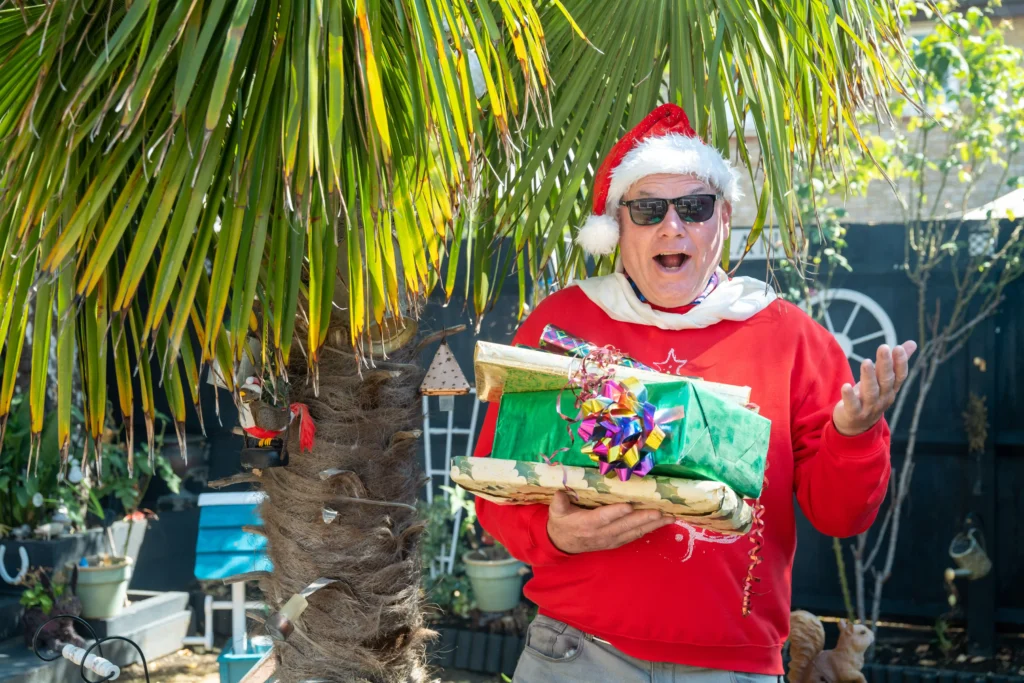 Man who has celebrated Christmas every day for 33 years says the heatwave made it 'unbearable' - so he now opens presents in a paddling pool.