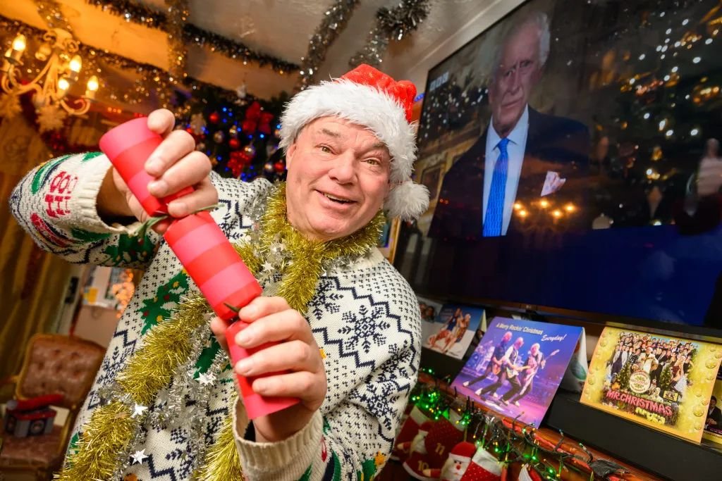 Man who has celebrated Christmas every day for 33 years says the heatwave made it 'unbearable' - so he now opens presents in a paddling pool.