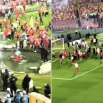 A football match was suspended for nearly an hour after rival fans invaded the pitch and brawled with sticks and chairs in front of thousands of spectators.