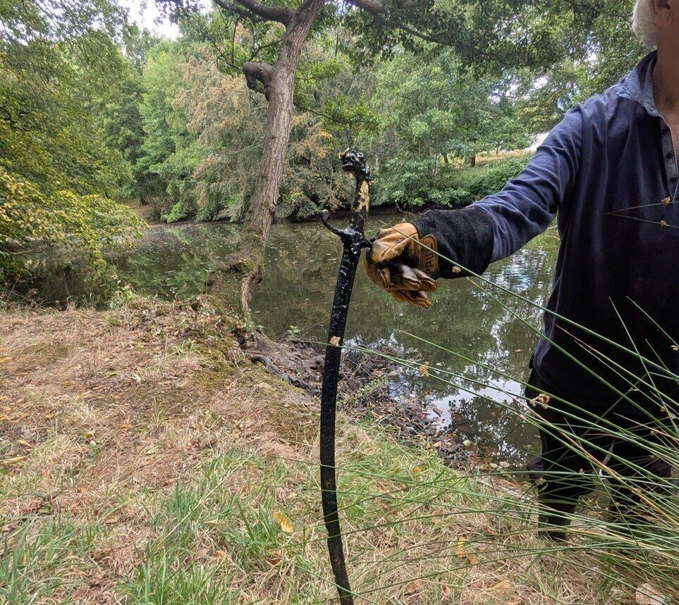 An 'Excalibur' style sword has been found sticking out of a castle lake after hot weather caused the water levels to plummet, revealing the hidden blade.