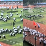 This is the bizarre moment students crawl on their knees through clouds of red smoke during a Squid Game-style military training drill at a Chinese college.