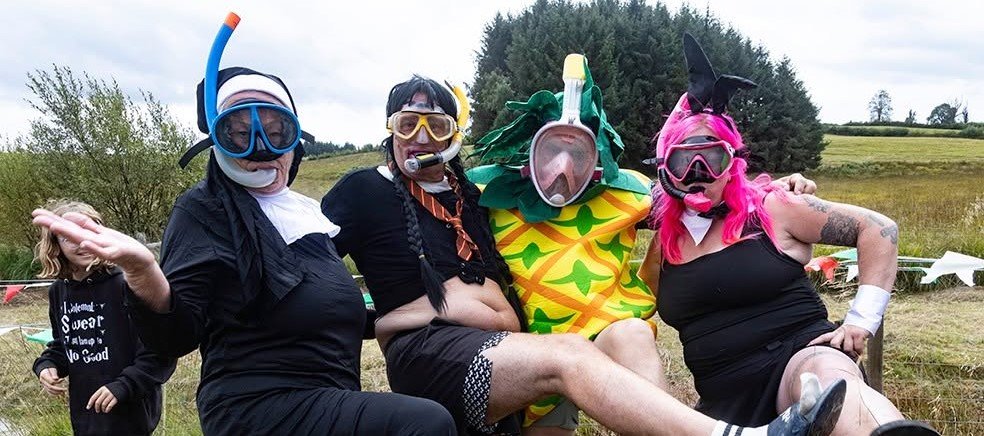 Daredevils dived headfirst into a filthy 120-yard bog as the World Bog Snorkelling Championships hit 40 years - with Emily Hall crowned champ in just 1:27.97.