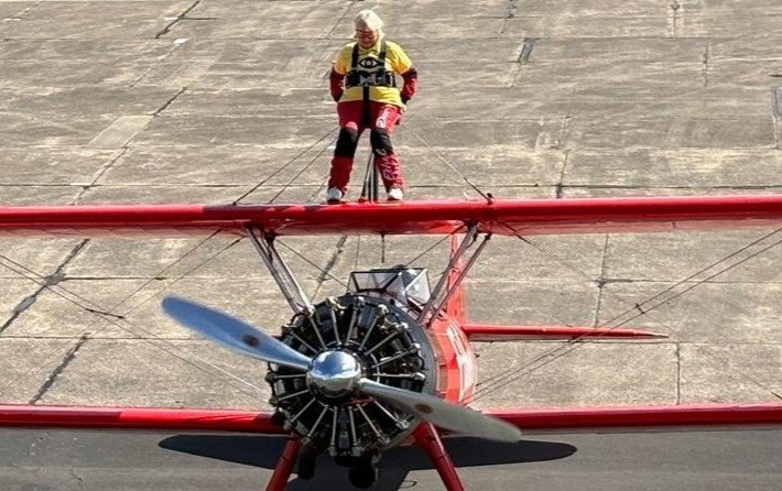 A daredevil gran has taken to the skies strapped to the top of a plane aged 80 - as her screaming grandchildren dubbed her 'Mad Nanna' and she raised £820 for charity.