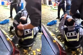 A cop's wig flew clean off while he wrestled a drunk suspect in South Korea - before a kind passerby calmly popped it back on his bald head without saying a word.