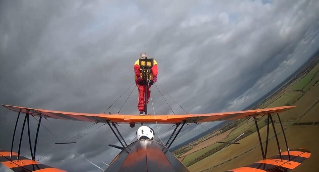 99-year-old Helga Duffy becomes world's oldest wing walker after strapping herself to plane. Inspired by another pensioner, she raised over £1,300 for charity.