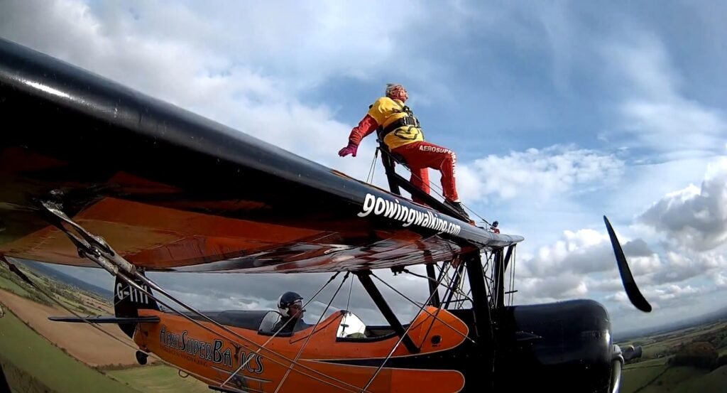 99-year-old Helga Duffy becomes world's oldest wing walker after strapping herself to plane. Inspired by another pensioner, she raised over £1,300 for charity.