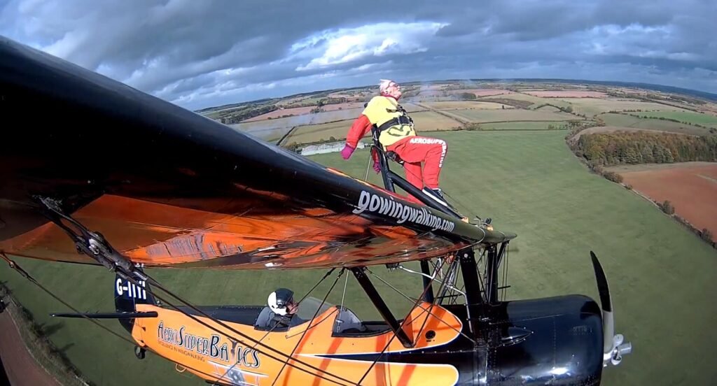 99-year-old Helga Duffy becomes world's oldest wing walker after strapping herself to plane. Inspired by another pensioner, she raised over £1,300 for charity.