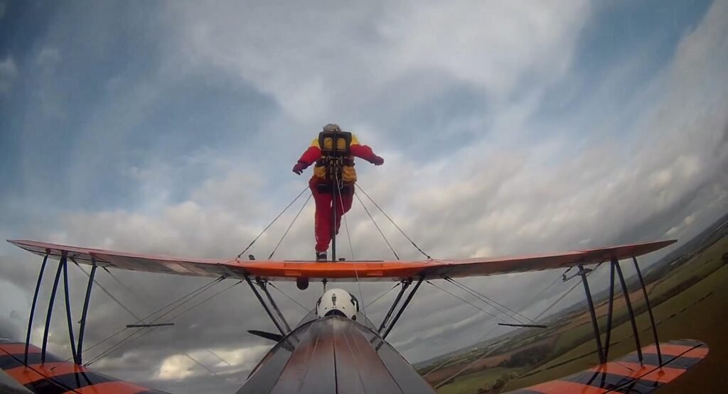 99-year-old Helga Duffy becomes world's oldest wing walker after strapping herself to plane. Inspired by another pensioner, she raised over £1,300 for charity.