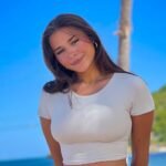 OnlyFans creator Sophie Rain on the beach in a white T-shirt