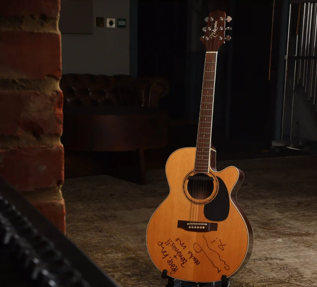 Noel Gallagher's guitar from Oasis's iconic 1996 MTV Unplugged performance has sold for a world record £226,800 at auction - and it was signed 'peace, love and bananas'.