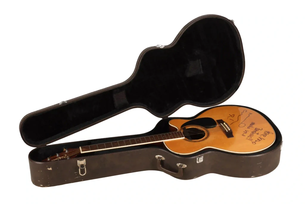 Noel Gallagher's guitar from Oasis's iconic 1996 MTV Unplugged performance has sold for a world record £226,800 at auction - and it was signed 'peace, love and bananas'.