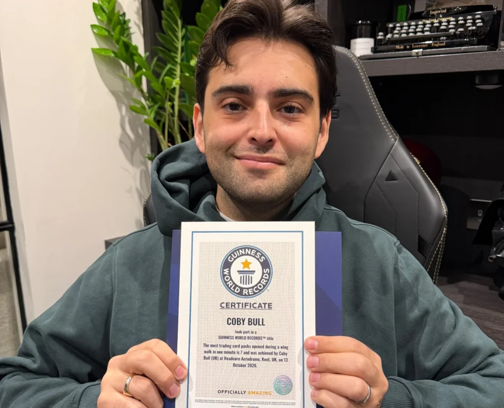 A daredevil collector has set a bizarre world record by opening £7,000 worth of trading card packs while strapped to the wing of a flying plane at speeds of up to 120mph.