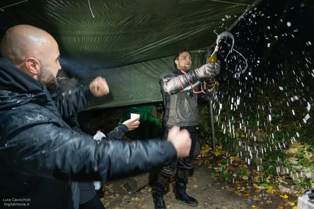 Team members celebrating with water splash at cave exit.