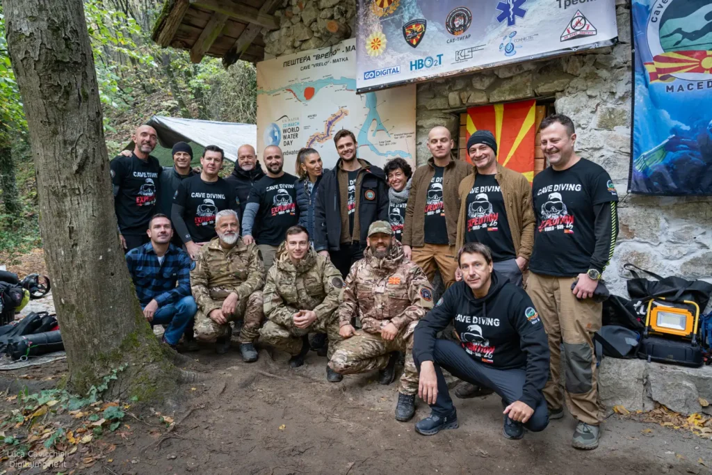 Large expedition team group photo at cave base camp.