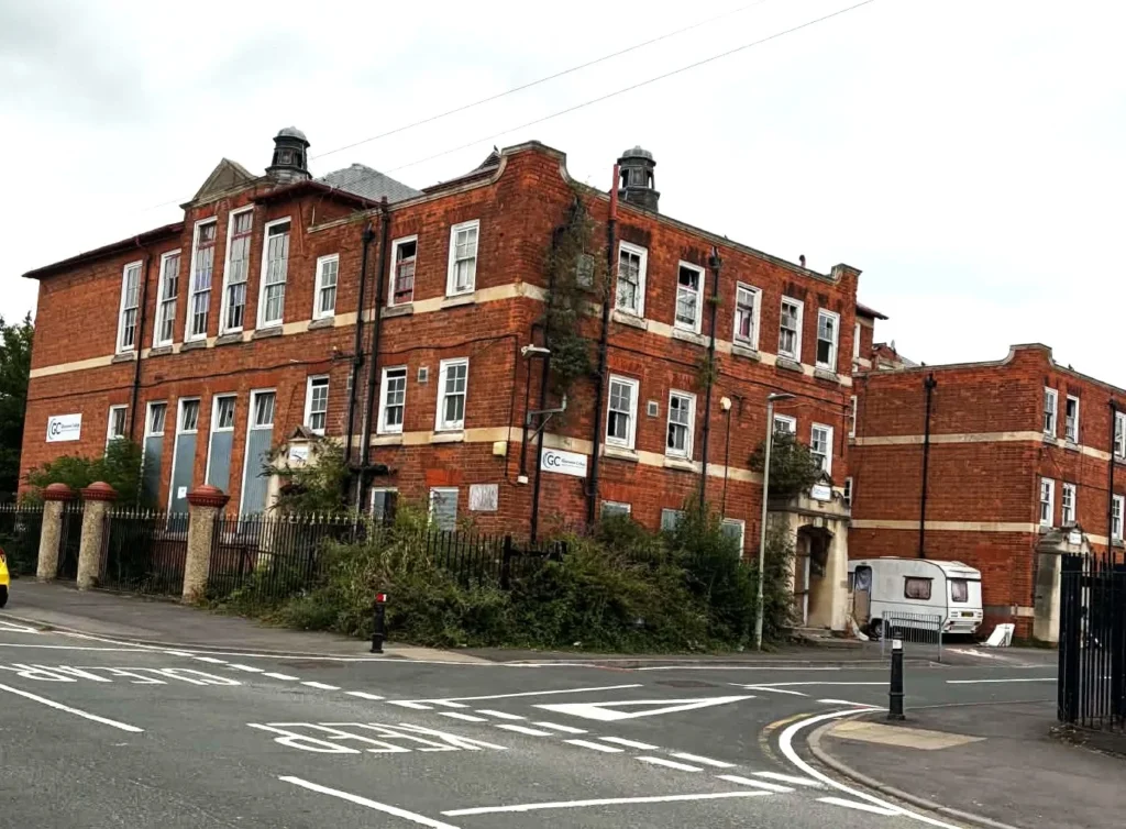 A caravan and mounds of fly-tipped rubbish have sparked fury after spilling onto a quiet Gloucester street near an abandoned school. Residents demand action.