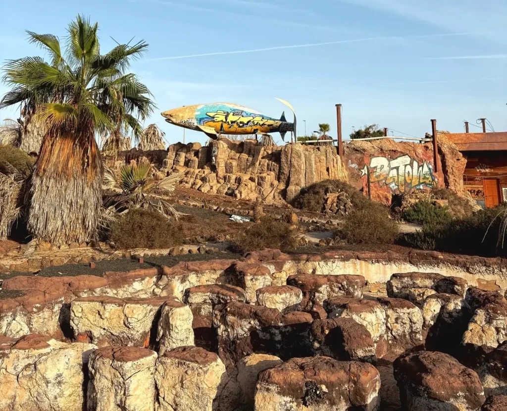 Eerie pictures reveal a former Spanish holiday attraction where sharks once swam, but now a giant graffiti-covered predator overlooks the decaying complex.