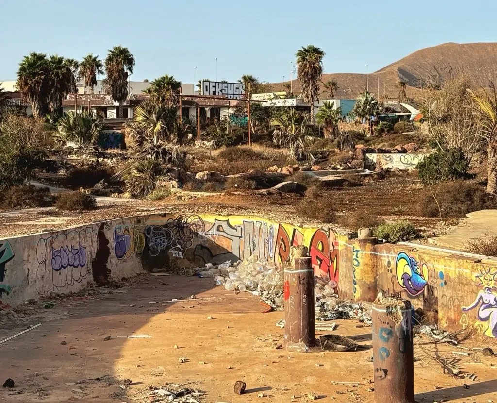 Eerie pictures reveal a former Spanish holiday attraction where sharks once swam, but now a giant graffiti-covered predator overlooks the decaying complex.