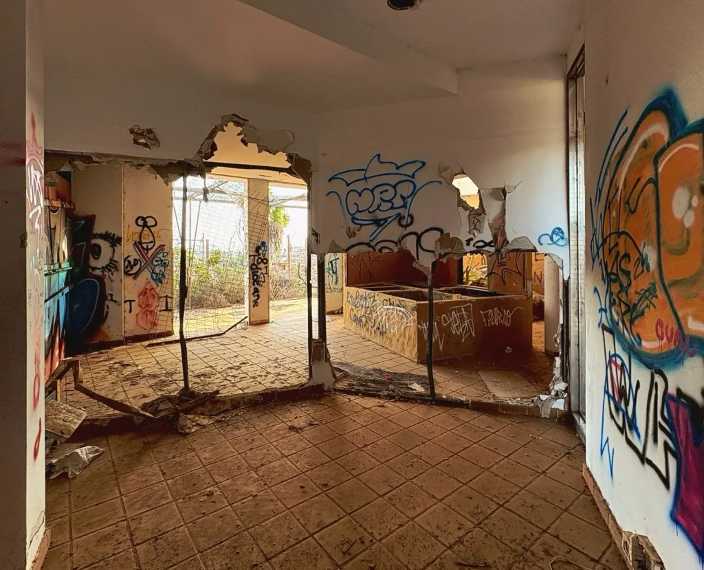 Eerie pictures reveal a former Spanish holiday attraction where sharks once swam, but now a giant graffiti-covered predator overlooks the decaying complex.