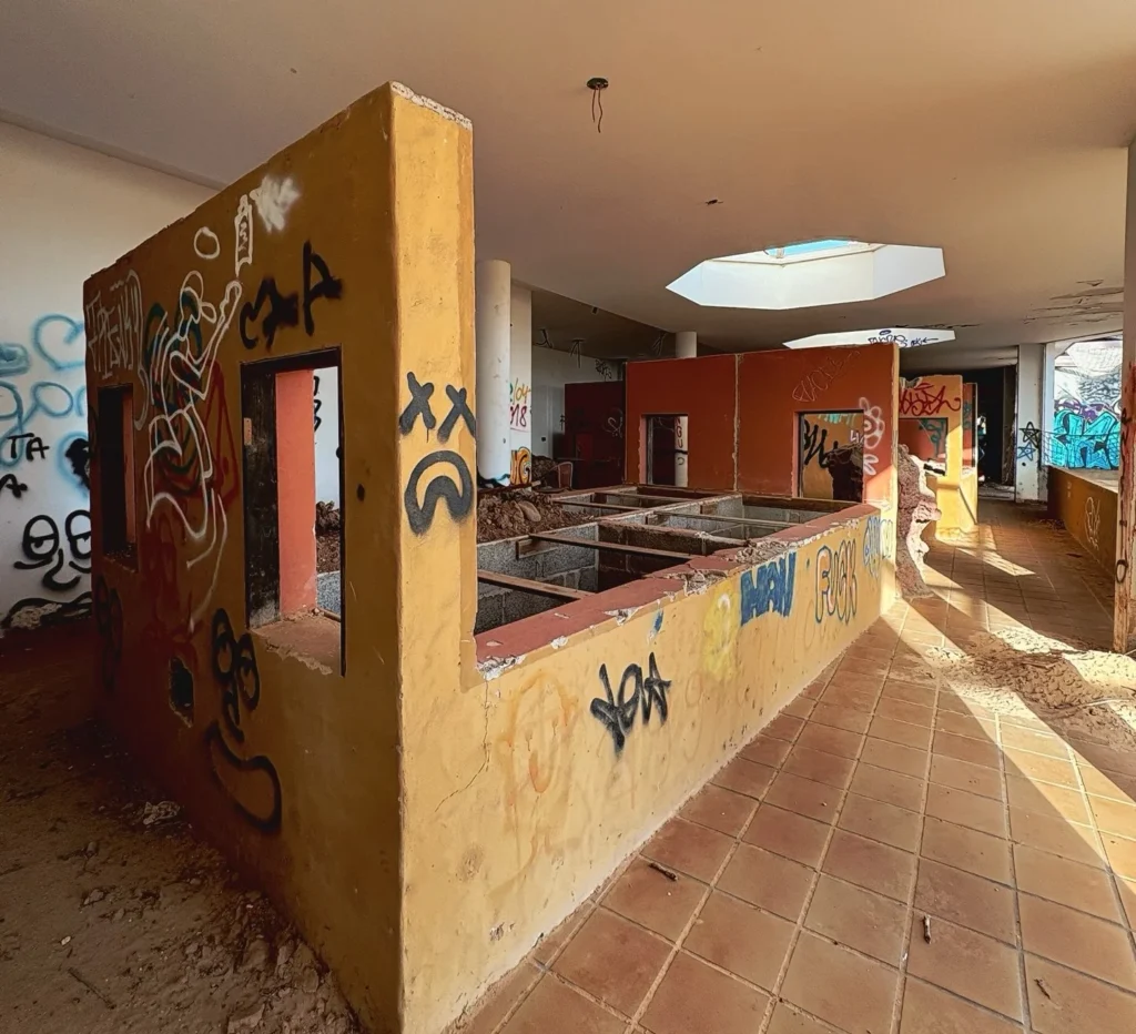 Eerie pictures reveal a former Spanish holiday attraction where sharks once swam, but now a giant graffiti-covered predator overlooks the decaying complex.