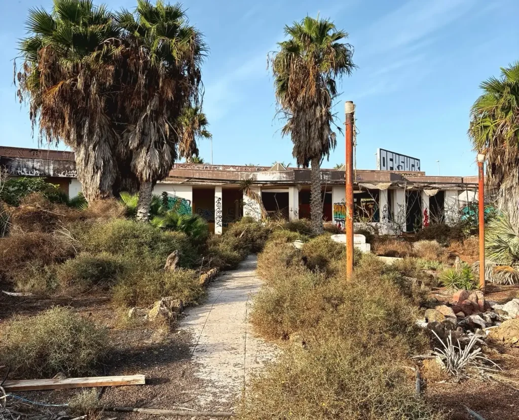 Eerie pictures reveal a former Spanish holiday attraction where sharks once swam, but now a giant graffiti-covered predator overlooks the decaying complex.