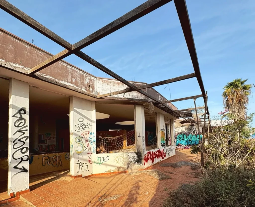 Eerie pictures reveal a former Spanish holiday attraction where sharks once swam, but now a giant graffiti-covered predator overlooks the decaying complex.